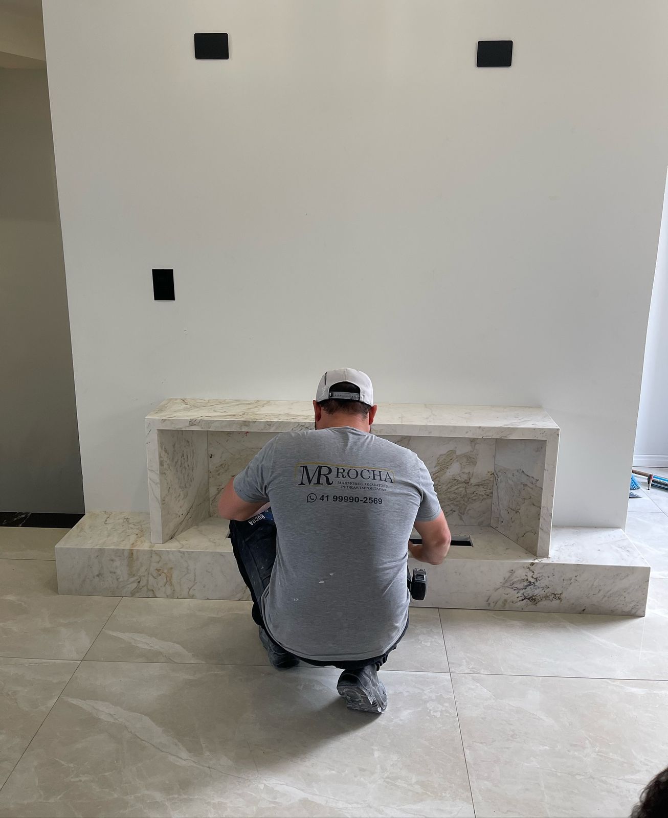 Instalador da equipe própria da MR Rocha, uniformizado, instalando bancada em mármore